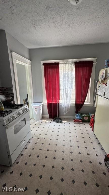 3415 E 114th St, Cleveland, OH 44104 - kitchen with white appliances, tile patterned floors, and a textured ceiling