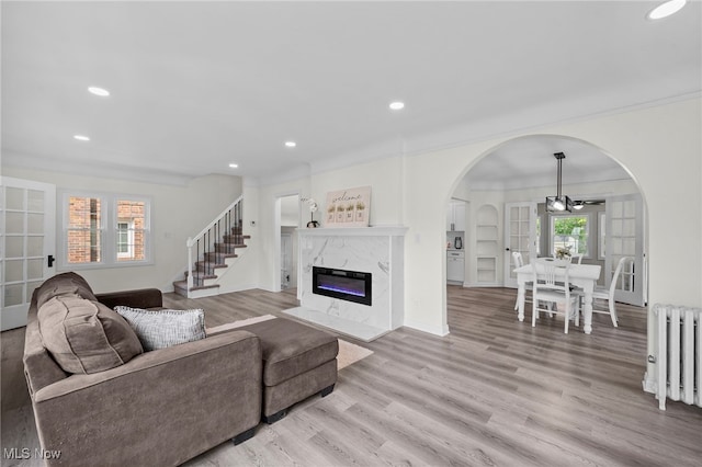 3609 Antisdale Ave, Cleveland Heights, OH 44118 - living room featuring radiator, recessed lighting, arched walkways, light wood finished floors, and a fireplace