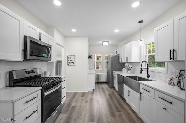 3609 Antisdale Ave, Cleveland Heights, OH 44118 - kitchen featuring stainless steel appliances, radiator, a sink, white cabinets, and recessed lighting
