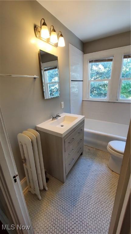 1901 Parkway Dr, Cleveland Heights, OH 44118 - bathroom with radiator, toilet, vanity, a bathtub, and tile patterned floors