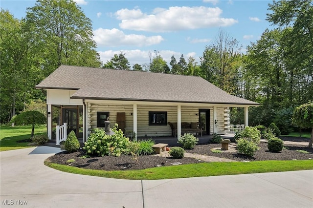 7090 Country Ln, Chagrin Falls, OH 44023 - log-style house featuring covered porch, driveway, and roof with shingles