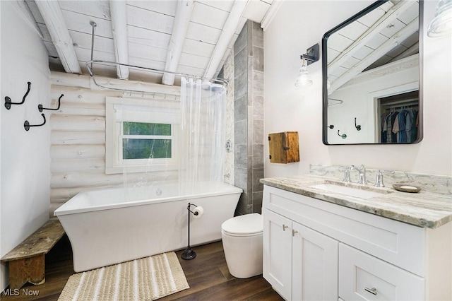 7090 Country Ln, Chagrin Falls, OH 44023 - bathroom featuring a freestanding bath, wood finished floors, vanity, toilet, and log walls