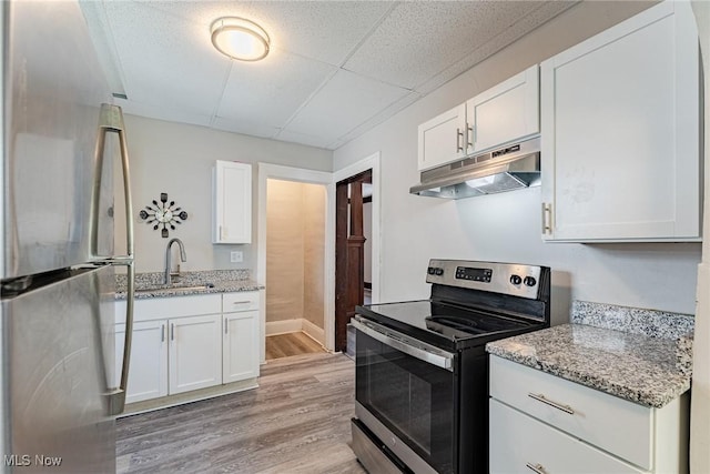 906 Beardsley St, Akron, OH 44311 - kitchen featuring stainless steel appliances, under cabinet range hood, a sink, light wood-style floors, and white cabinets