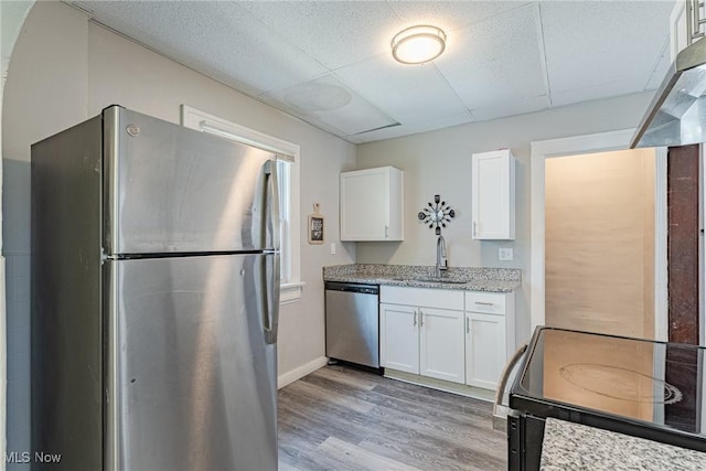 906 Beardsley St, Akron, OH 44311 - kitchen with appliances with stainless steel finishes, a sink, white cabinetry, light wood-style floors, and light stone counters