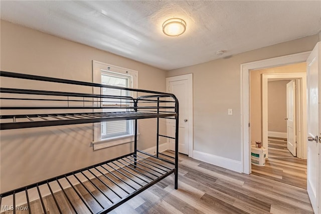 906 Beardsley St, Akron, OH 44311 - unfurnished bedroom featuring light wood finished floors, baseboards, and a textured ceiling