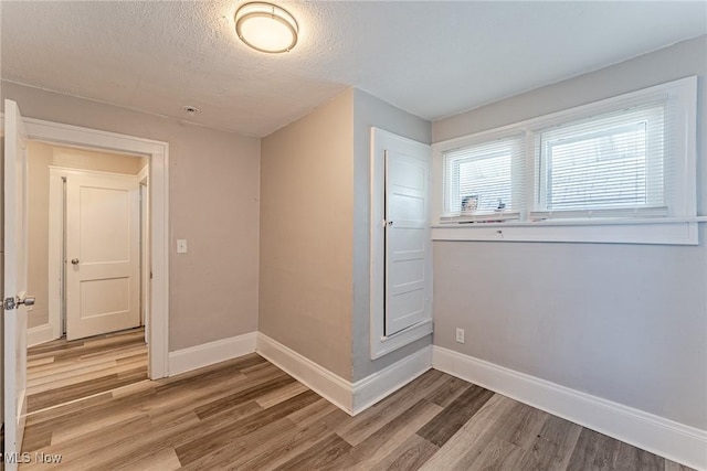 906 Beardsley St, Akron, OH 44311 - spare room featuring light wood-type flooring, baseboards, and a textured ceiling