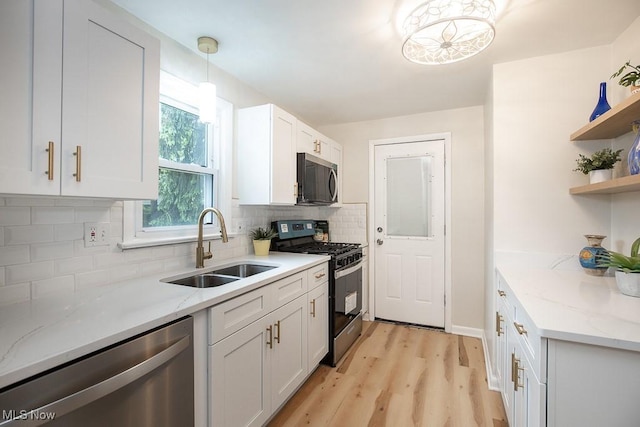 3762 Covington Rd, South Euclid, OH 44121 - kitchen featuring stainless steel appliances, a sink, open shelves, decorative backsplash, and light wood finished floors