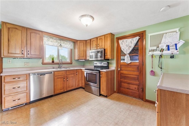 22938 US Route 30, Minerva, OH 44657 - kitchen with appliances with stainless steel finishes, a sink, light countertops, and brown cabinets