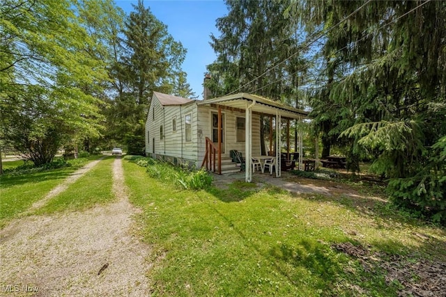 7100 Barton Rd, North Olmsted, OH 44070 - view of front of home featuring driveway, a chimney, and a front lawn