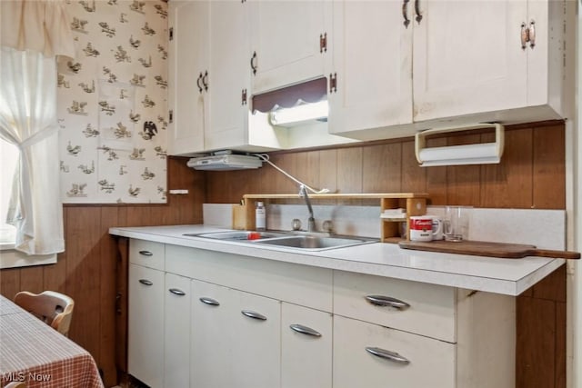 7100 Barton Rd, North Olmsted, OH 44070 - kitchen with a sink, wallpapered walls, a wainscoted wall, light countertops, and white cabinets