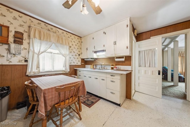 7100 Barton Rd, North Olmsted, OH 44070 - kitchen with wood walls, a ceiling fan, wainscoting, light countertops, and white cabinets