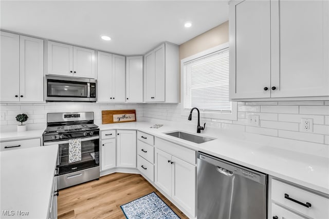 1255 E 351st St, Eastlake, OH 44095 - kitchen featuring appliances with stainless steel finishes, a sink, light countertops, white cabinets, and recessed lighting
