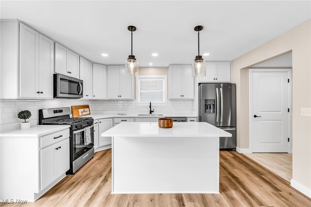1255 E 351st St, Eastlake, OH 44095 - kitchen with appliances with stainless steel finishes, a sink, light wood finished floors, light countertops, and backsplash