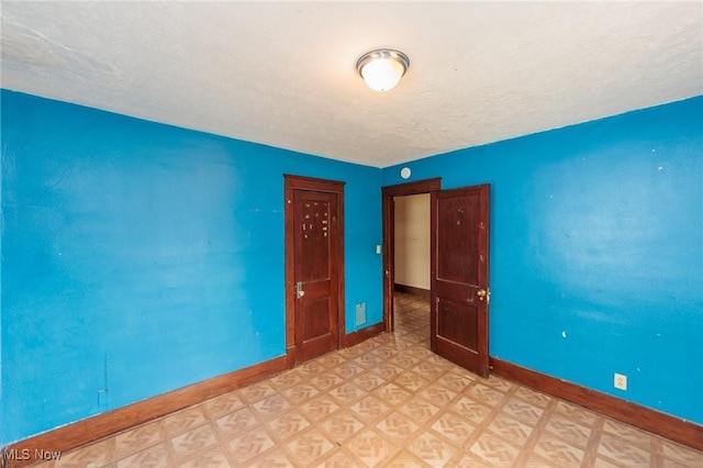 1222 W 6th St, Lorain, OH 44052 - empty room featuring baseboards, light floors, and a textured ceiling