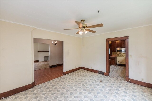 1222 W 6th St, Lorain, OH 44052 - unfurnished room featuring ceiling fan, a chandelier, baseboards, crown molding, and a pendent fire sprinkler