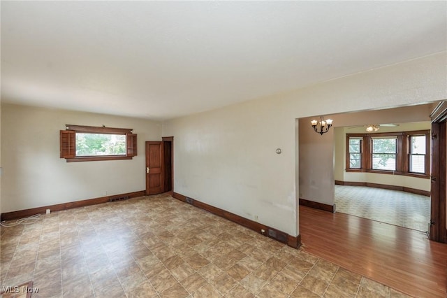1222 W 6th St, Lorain, OH 44052 - empty room with a chandelier, plenty of natural light, and baseboards