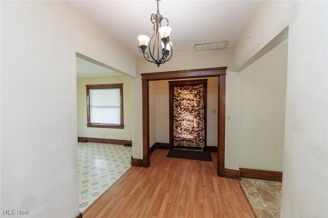 1222 W 6th St, Lorain, OH 44052 - entrance foyer featuring baseboards, a chandelier, and light wood-style flooring