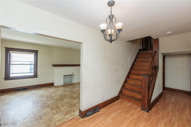 1222 W 6th St, Lorain, OH 44052 - stairs with baseboards and a chandelier