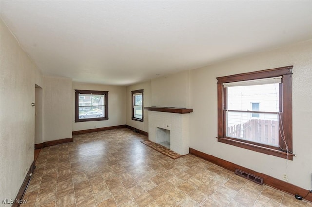 1222 W 6th St, Lorain, OH 44052 - unfurnished living room with a brick fireplace and baseboards