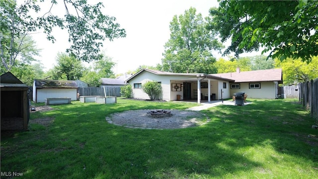 3221 Greenfield St NW, Warren, OH 44485 - rear view of property featuring an outdoor fire pit, a fenced backyard, a patio area, and an outdoor structure