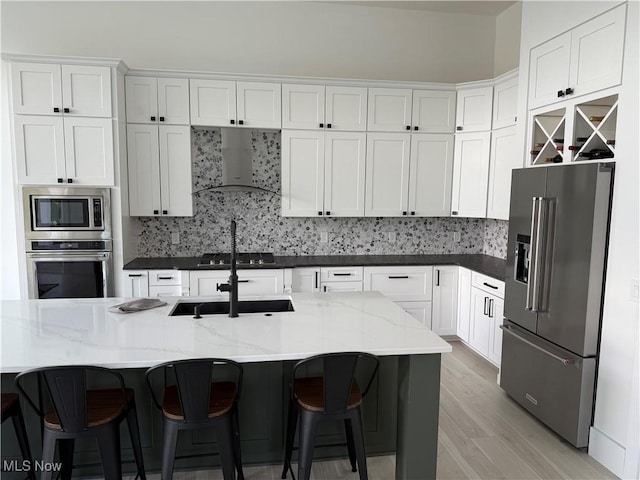 5771 E Blvd NW, Canton, OH 44718 - kitchen featuring stainless steel appliances, wall chimney range hood, backsplash, light wood-type flooring, and white cabinets