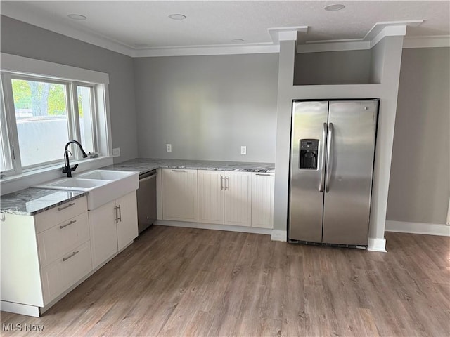 5771 E Blvd NW, Canton, OH 44718 - kitchen with appliances with stainless steel finishes, crown molding, light wood finished floors, light stone countertops, and white cabinetry