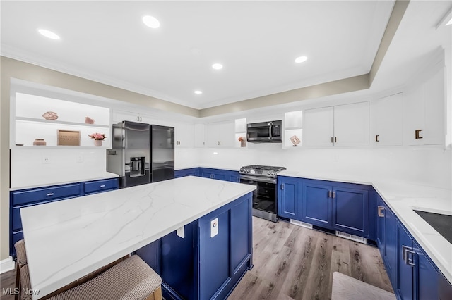 4371 Pine Lake Dr, Medina, OH 44256 - kitchen with stainless steel appliances, blue cabinetry, open shelves, light stone countertops, and light wood-style flooring