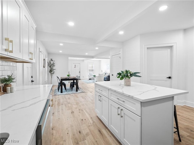 2295 Thurman Ave, Cleveland, OH 44113 - kitchen with recessed lighting, light wood-type flooring, beam ceiling, white cabinets, and light stone counters