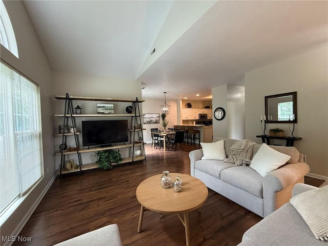 5645 Clingan Rd Unit 2D, Struthers, OH 44471 - living room with baseboards, wood finished floors, healthy amount of natural light, and vaulted ceiling