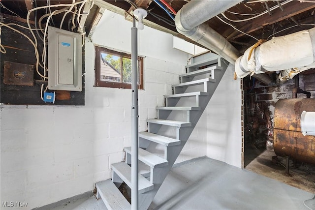 159 Locust St, Wintersville, OH 43953 - basement featuring electric panel, oil tank, stairs, and concrete block wall
