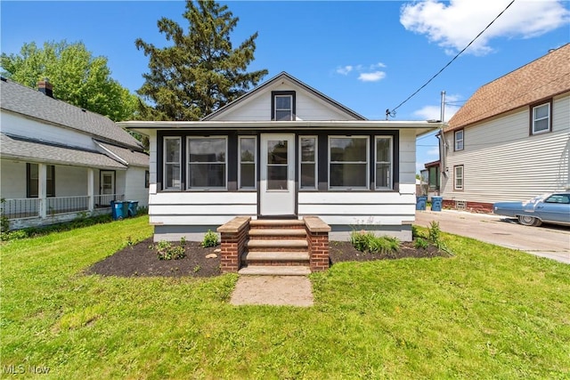210 W 39th St, Lorain, OH 44052 - view of front of home with a front yard and a sunroom