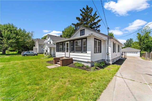 210 W 39th St, Lorain, OH 44052 - view of property exterior featuring an outdoor structure, a garage, and a lawn