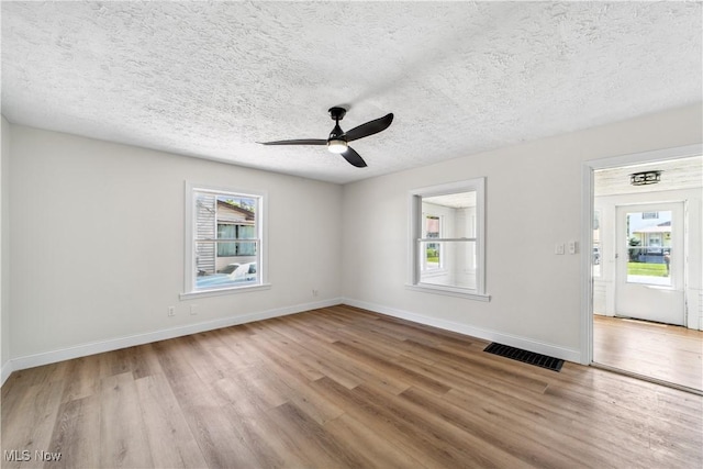 210 W 39th St, Lorain, OH 44052 - unfurnished room with plenty of natural light, wood finished floors, a ceiling fan, and a textured ceiling