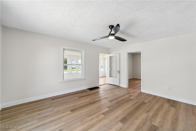210 W 39th St, Lorain, OH 44052 - unfurnished bedroom with light wood-style flooring, a textured ceiling, baseboards, and ceiling fan
