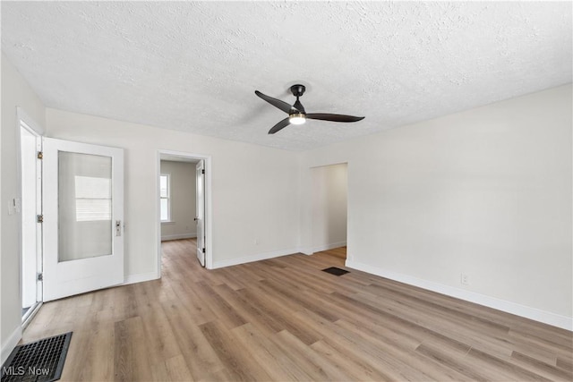 210 W 39th St, Lorain, OH 44052 - unfurnished living room with light wood-style floors, a textured ceiling, ceiling fan, and baseboards