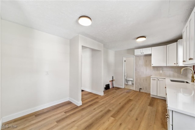 210 W 39th St, Lorain, OH 44052 - kitchen with a sink, light countertops, light wood-type flooring, and white cabinetry