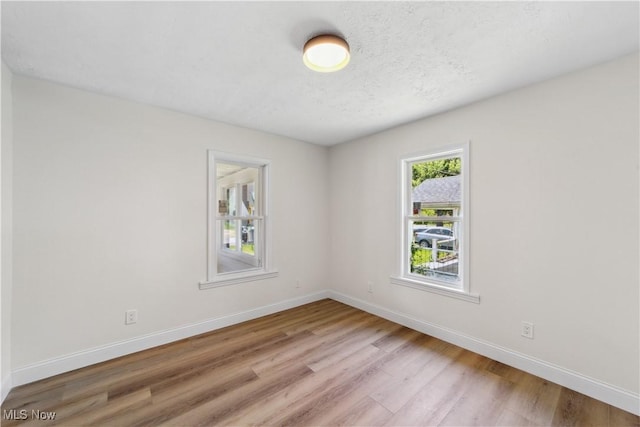 210 W 39th St, Lorain, OH 44052 - unfurnished room featuring light wood-style flooring, baseboards, and a textured ceiling