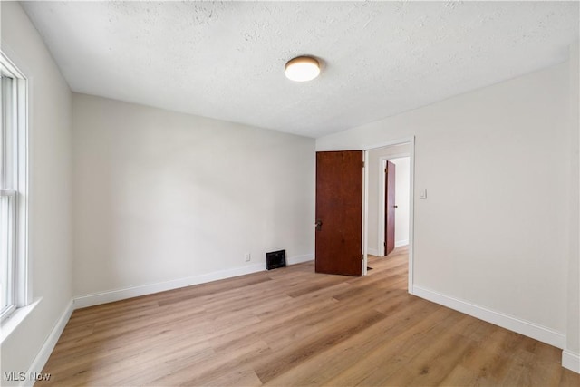 210 W 39th St, Lorain, OH 44052 - spare room featuring light wood-style floors, a textured ceiling, and baseboards