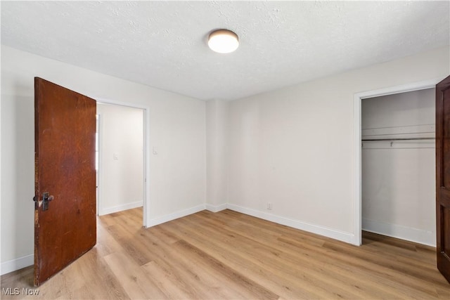 210 W 39th St, Lorain, OH 44052 - unfurnished bedroom featuring light wood-style floors, a closet, baseboards, and a textured ceiling