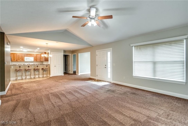 165 Woodbury Glen St, Hartville, OH 44632 - unfurnished living room featuring a ceiling fan, a chandelier, carpet, and vaulted ceiling