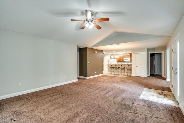 165 Woodbury Glen St, Hartville, OH 44632 - unfurnished living room with a ceiling fan, carpet flooring, baseboards, lofted ceiling, and a chandelier