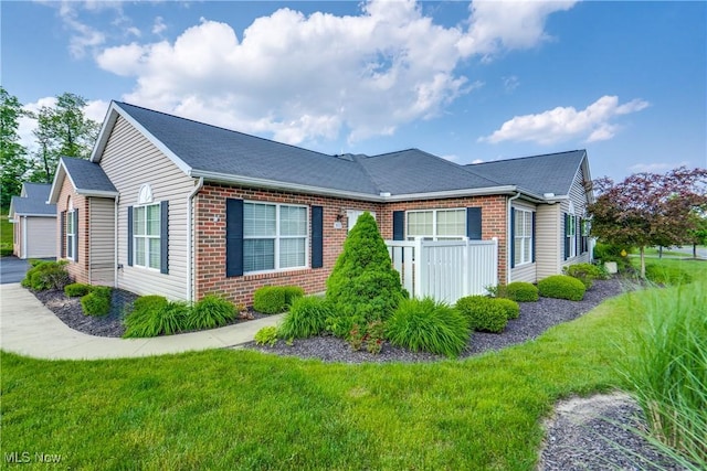 165 Woodbury Glen St, Hartville, OH 44632 - view of side of property featuring brick siding, a lawn, and roof with shingles
