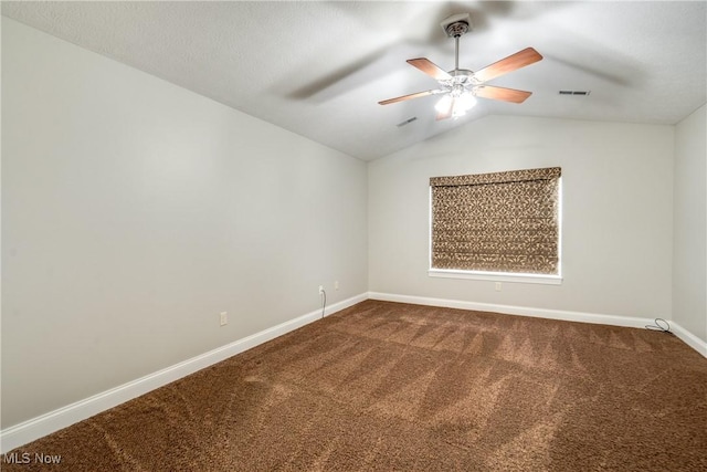 165 Woodbury Glen St, Hartville, OH 44632 - spare room featuring dark colored carpet, baseboards, vaulted ceiling, and a ceiling fan