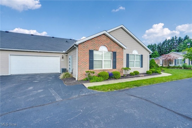 165 Woodbury Glen St, Hartville, OH 44632 - view of front of home featuring asphalt driveway, brick siding, an attached garage, and central air condition unit