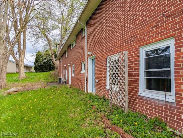 3189 Union Ave SE, Minerva, OH 44657 - view of side of home featuring brick siding, central air condition unit, and a lawn