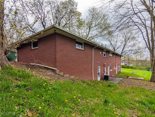 3189 Union Ave SE, Minerva, OH 44657 - view of home's exterior with brick siding, cooling unit, and a yard