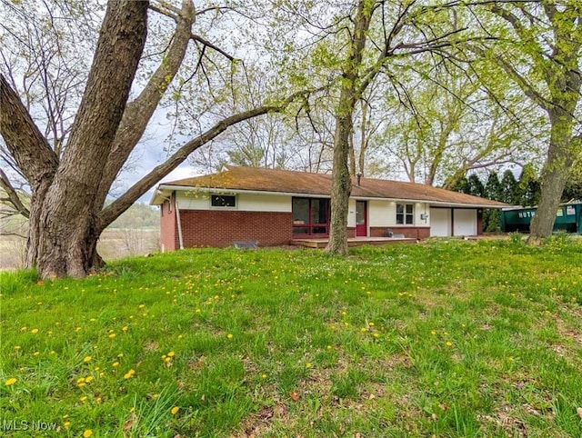 3189 Union Ave SE, Minerva, OH 44657 - view of front of house with brick siding, a front yard, and a garage