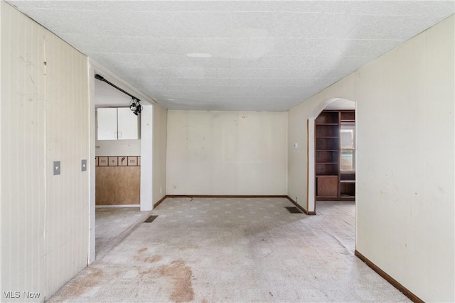 365 Stephens Rd, Akron, OH 44312 - spare room with arched walkways, carpet, baseboards, and wooden walls
