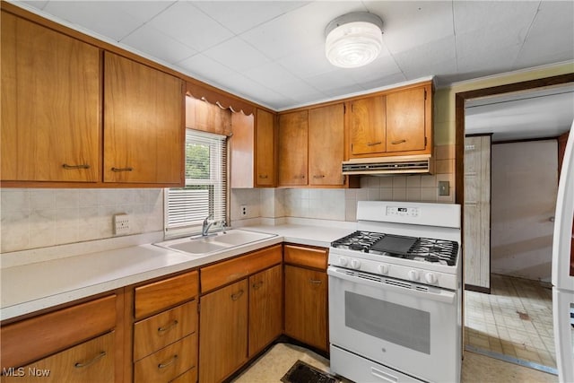 365 Stephens Rd, Akron, OH 44312 - kitchen featuring white gas stove, under cabinet range hood, a sink, light flooring, and brown cabinetry