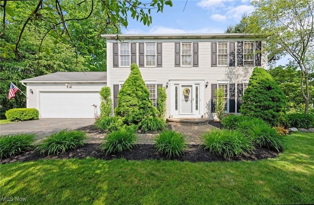 11291 Highland View Dr, Chardon, OH 44024 - colonial house with driveway, an attached garage, and a front lawn
